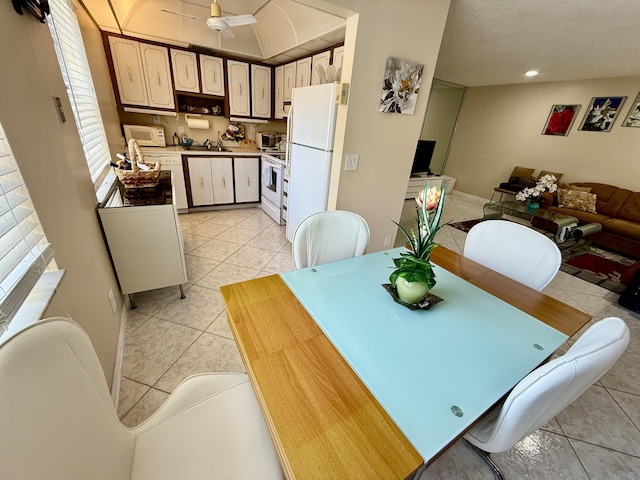 dining area featuring light tile patterned flooring, ceiling fan, and a textured ceiling
