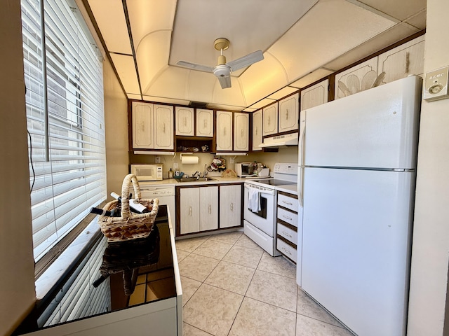 kitchen with white appliances, under cabinet range hood, light tile patterned flooring, ceiling fan, and light countertops