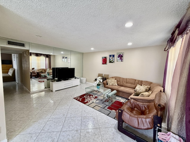 living room featuring recessed lighting, a textured ceiling, and light tile patterned floors