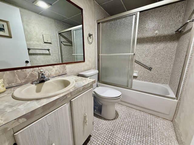 bathroom with toilet, vanity, enclosed tub / shower combo, and tile patterned flooring