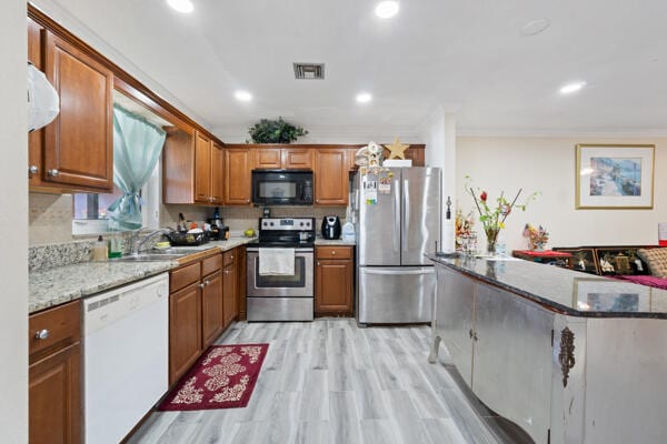 6531 SE Federal Hwy SE Unit Q108, Stuart, FL 34997 - kitchen with brown cabinets, ornamental molding, stainless steel appliances, and a sink