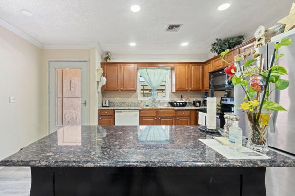 6531 SE Federal Hwy SE Unit Q108, Stuart, FL 34997 - kitchen with visible vents, brown cabinetry, crown molding, black microwave, and dishwasher