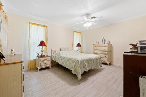 6531 SE Federal Hwy SE Unit Q108, Stuart, FL 34997 - bedroom featuring ceiling fan, baseboards, crown molding, and light wood finished floors