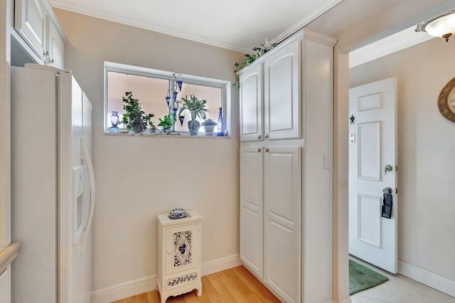 2669 S Garden Dr S Unit 401, Lake Worth, FL 33461 - interior space with white fridge with ice dispenser, white cabinetry, crown molding, and baseboards