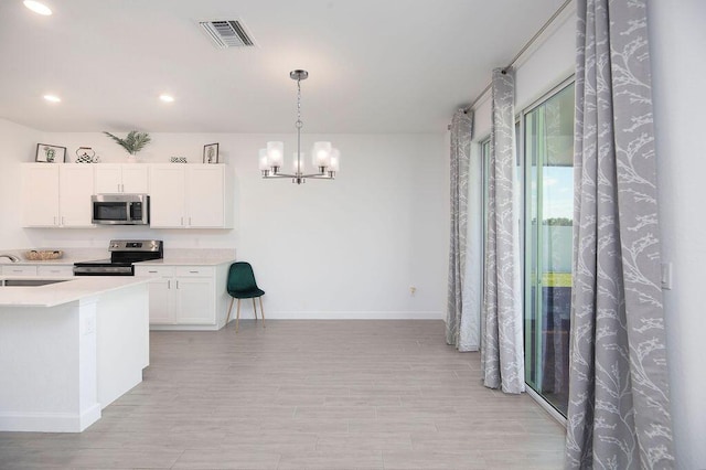 7568 NW Deysbrook Ln, Port Saint Lucie, FL 34987 - kitchen with an inviting chandelier, white cabinetry, stainless steel appliances, baseboards, and visible vents