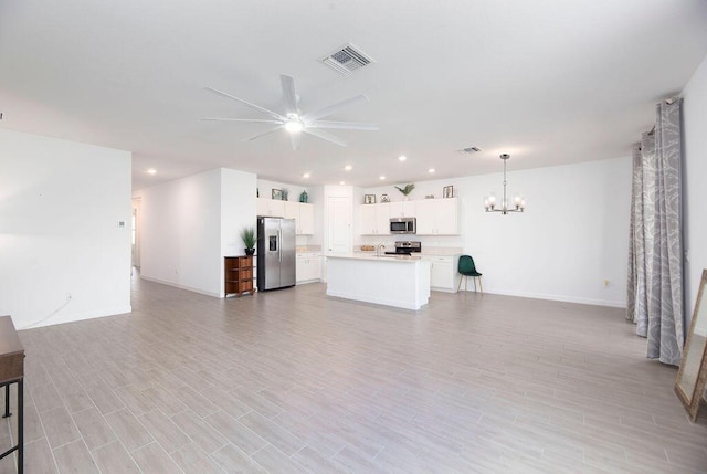 7568 NW Deysbrook Ln, Port Saint Lucie, FL 34987 - unfurnished living room with recessed lighting, visible vents, baseboards, and ceiling fan with notable chandelier