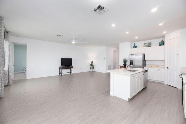 7568 NW Deysbrook Ln, Port Saint Lucie, FL 34987 - kitchen featuring stainless steel appliances, a ceiling fan, visible vents, white cabinetry, and open floor plan