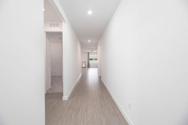 7568 NW Deysbrook Ln, Port Saint Lucie, FL 34987 - hallway with light wood-type flooring, recessed lighting, visible vents, and baseboards