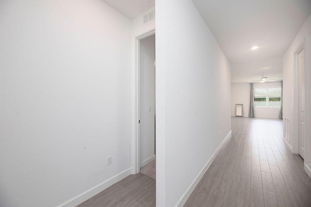7568 NW Deysbrook Ln, Port Saint Lucie, FL 34987 - corridor with wood finished floors, visible vents, and baseboards