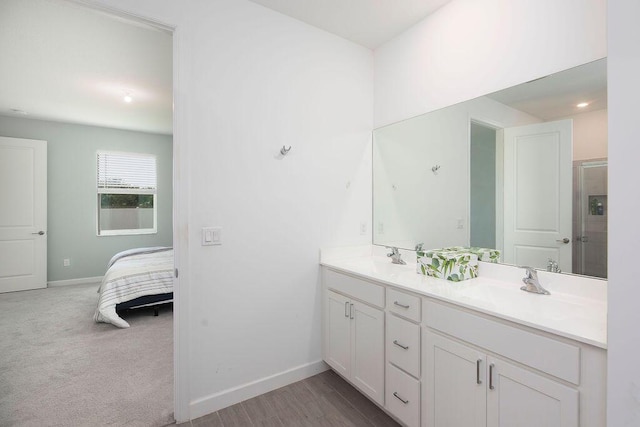 7568 NW Deysbrook Ln, Port Saint Lucie, FL 34987 - ensuite bathroom featuring double vanity, a sink, connected bathroom, and baseboards