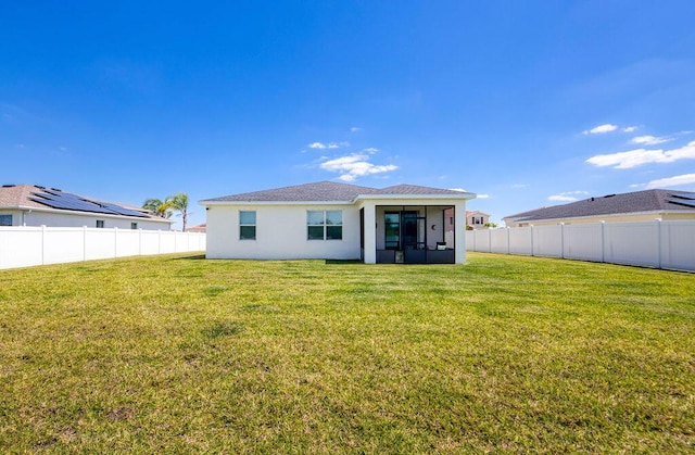 7568 NW Deysbrook Ln, Port Saint Lucie, FL 34987 - back of house with a lawn, a fenced backyard, stucco siding, and a sunroom