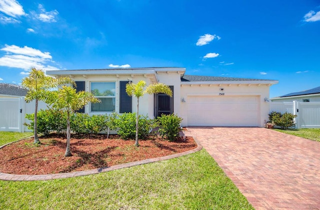 7568 NW Deysbrook Ln, Port Saint Lucie, FL 34987 - ranch-style house with fence, decorative driveway, a front yard, an attached garage, and stucco siding