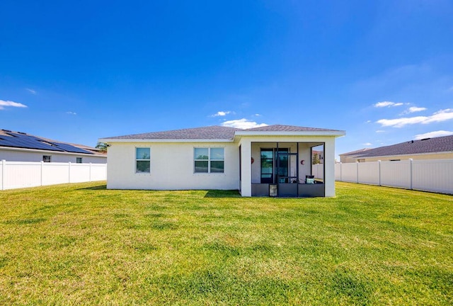 7568 NW Deysbrook Ln, Port Saint Lucie, FL 34987 - back of house with a sunroom, a yard, stucco siding, and a fenced backyard