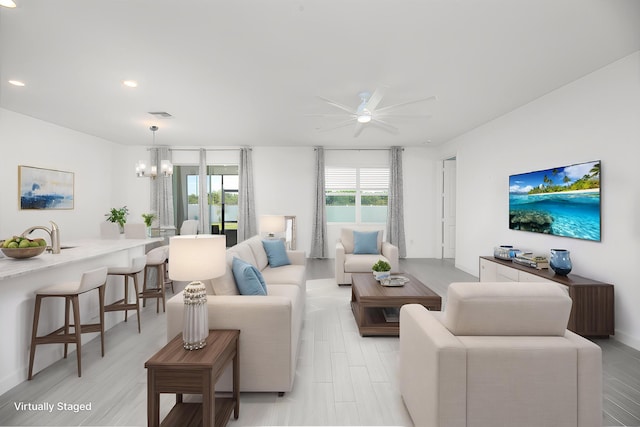 7568 NW Deysbrook Ln, Port Saint Lucie, FL 34987 - living area with recessed lighting, visible vents, light wood-style floors, and ceiling fan with notable chandelier