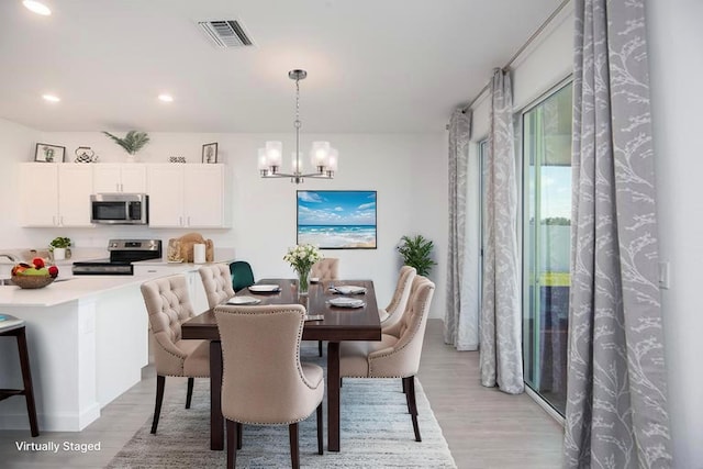 7568 NW Deysbrook Ln, Port Saint Lucie, FL 34987 - dining area with light wood-style flooring, visible vents, recessed lighting, and a notable chandelier