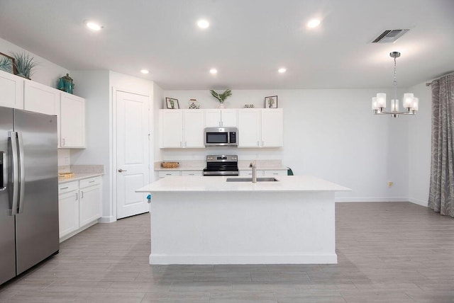 7568 NW Deysbrook Ln, Port Saint Lucie, FL 34987 - kitchen with stainless steel appliances, light countertops, a sink, white cabinetry, and visible vents