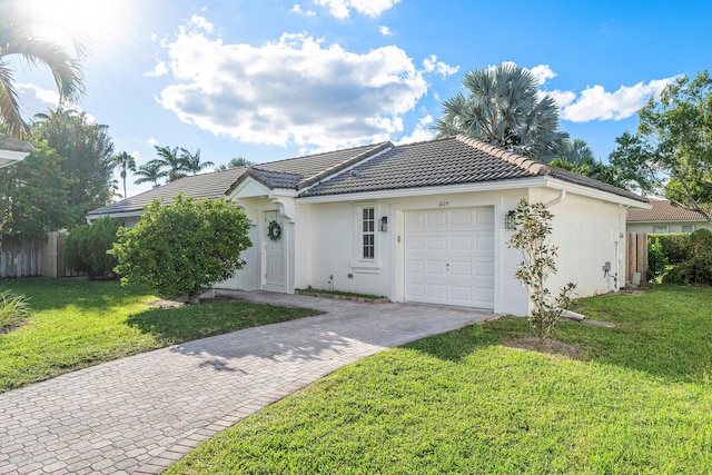 ranch-style home with a tile roof, fence, a garage, stucco siding, and decorative driveway