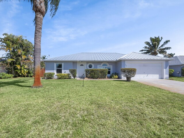509 SW Feldman Ave, Port Saint Lucie, FL 34953 - ranch-style home featuring stucco siding, a garage, driveway, and a metal roof