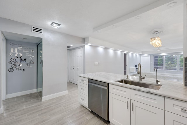 9305 Flynn Cir Unit 8, Boca Raton, FL 33496 - kitchen with stainless steel dishwasher, white cabinets, light stone counters, and light wood-style flooring