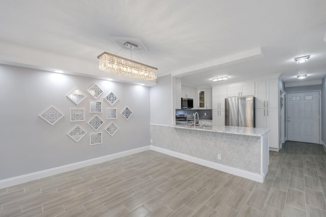 9305 Flynn Cir Unit 8, Boca Raton, FL 33496 - kitchen with stainless steel appliances, a peninsula, white cabinetry, and light wood finished floors