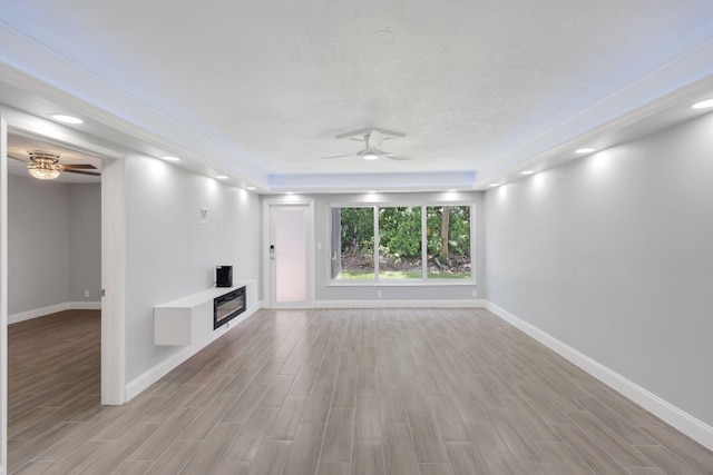 9305 Flynn Cir Unit 8, Boca Raton, FL 33496 - unfurnished living room featuring a ceiling fan, light wood-style flooring, a glass covered fireplace, and recessed lighting