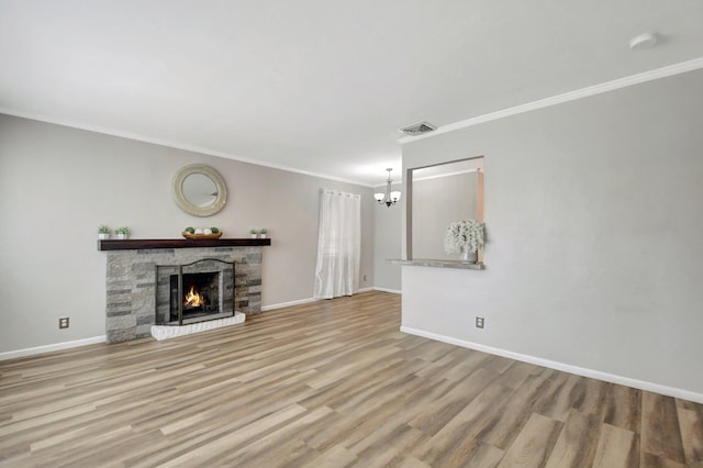 953 Churchill Rd, West Palm Beach, FL 33405 - unfurnished living room with a chandelier, ornamental molding, wood finished floors, baseboards, and a stone fireplace