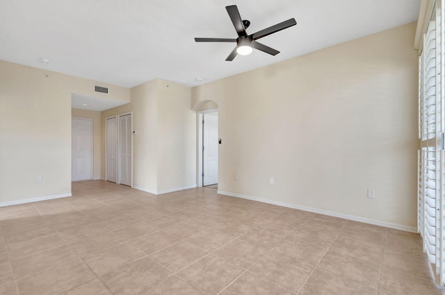 11039 Legacy Blvd Unit 203, Palm Beach Gardens, FL 33410 - empty room with arched walkways, baseboards, visible vents, ceiling fan, and light tile patterned floors
