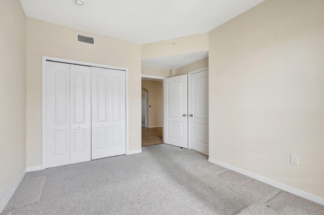 11039 Legacy Blvd Unit 203, Palm Beach Gardens, FL 33410 - unfurnished bedroom featuring arched walkways, baseboards, visible vents, and carpet