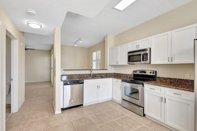 11039 Legacy Blvd Unit 203, Palm Beach Gardens, FL 33410 - kitchen featuring white cabinets, dark stone countertops, appliances with stainless steel finishes, and light tile patterned floors