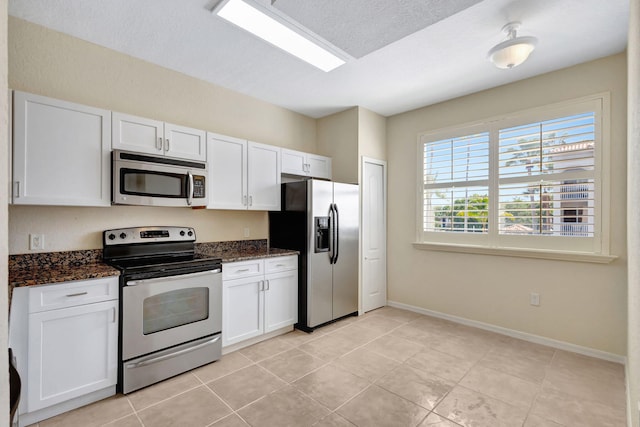 11039 Legacy Blvd Unit 203, Palm Beach Gardens, FL 33410 - kitchen featuring dark stone counters, baseboards, white cabinetry, and stainless steel appliances