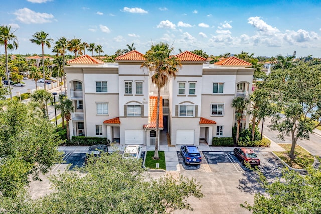 11039 Legacy Blvd Unit 203, Palm Beach Gardens, FL 33410 - view of front of house with a tile roof, uncovered parking, and stucco siding