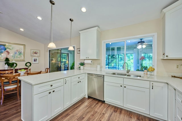 527 10th Ct, Vero Beach, FL 32962 - kitchen featuring dishwasher, a sink, a peninsula, light countertops, and white cabinetry
