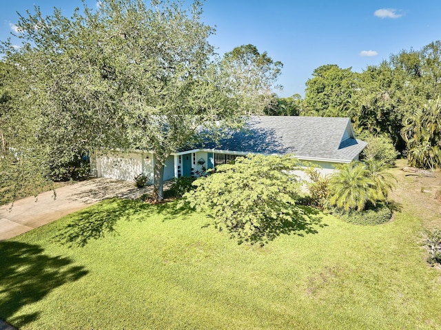 527 10th Ct, Vero Beach, FL 32962 - view of front of property featuring concrete driveway, a front lawn, and an attached garage