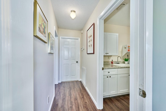 527 10th Ct, Vero Beach, FL 32962 - hall featuring a sink, dark wood-style floors, baseboards, and a textured ceiling