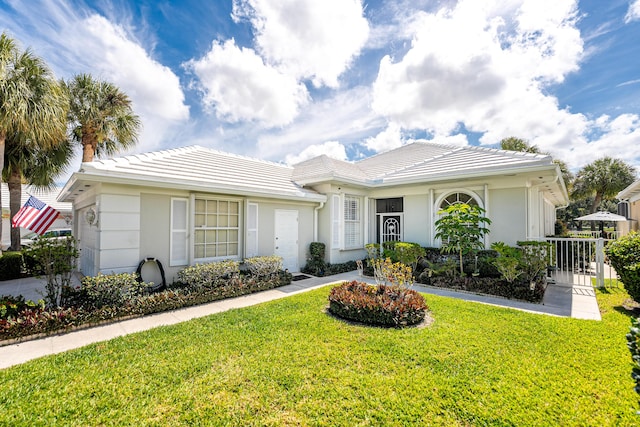 8483 Beaconhill Rd, Palm Beach Gardens, FL 33410 - ranch-style house featuring a front lawn, a tile roof, and stucco siding