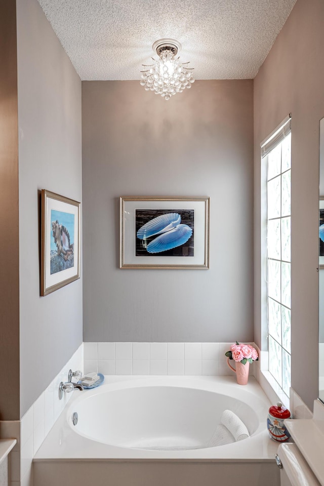 8483 Beaconhill Rd, Palm Beach Gardens, FL 33410 - full bath featuring a textured ceiling, a bath, and a chandelier