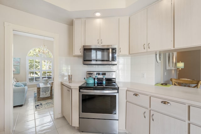 8483 Beaconhill Rd, Palm Beach Gardens, FL 33410 - kitchen with stainless steel appliances, light countertops, light tile patterned flooring, and tasteful backsplash