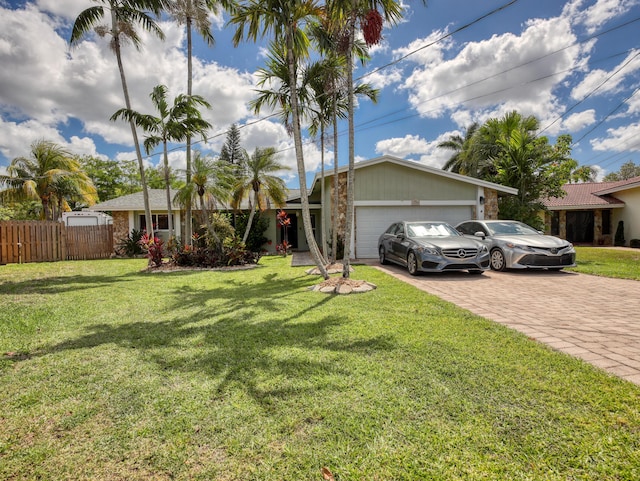 single story home with fence, decorative driveway, a front lawn, and a garage