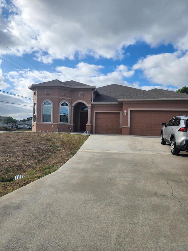 1691 SW Buttercup Ave, Port Saint Lucie, FL 34953 - view of front of house featuring concrete driveway, stucco siding, and a garage