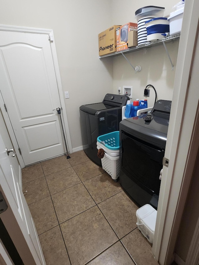 1691 SW Buttercup Ave, Port Saint Lucie, FL 34953 - clothes washing area with tile patterned floors, baseboards, laundry area, and washer and clothes dryer