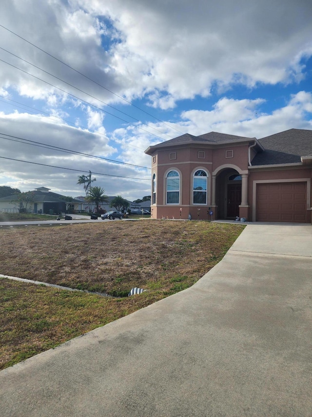 1691 SW Buttercup Ave, Port Saint Lucie, FL 34953 - view of front of home featuring an attached garage, stucco siding, and concrete driveway
