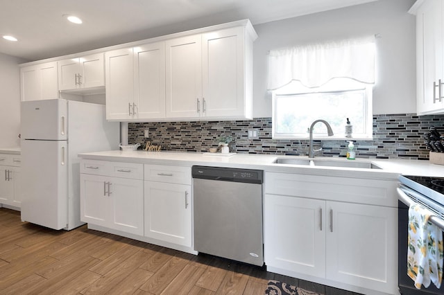 kitchen with light wood-type flooring, a sink, white cabinetry, and appliances with stainless steel finishes