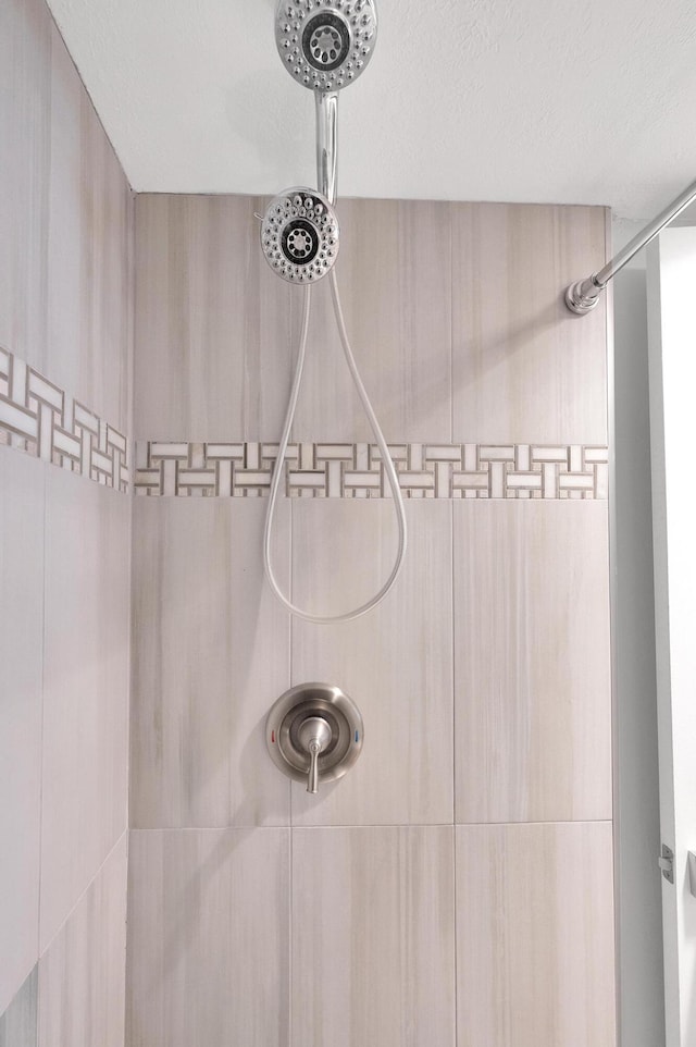 interior space featuring a textured ceiling and tiled shower