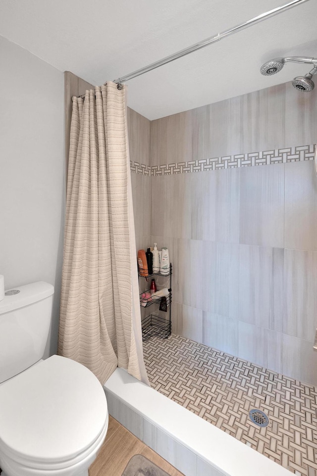 full bath featuring toilet and tiled shower