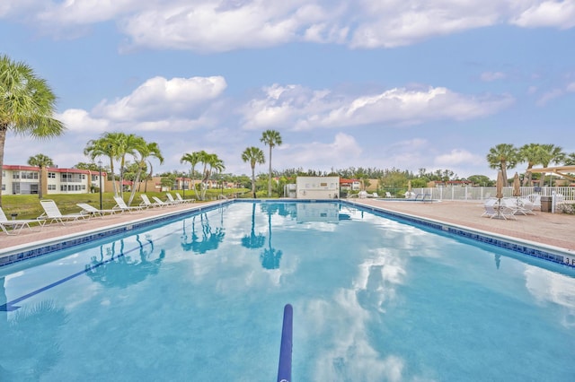 pool with a patio and fence