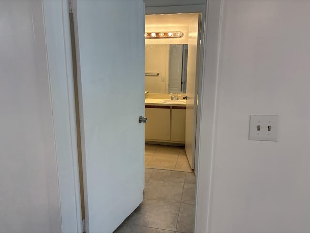 corridor featuring a sink and light tile patterned floors