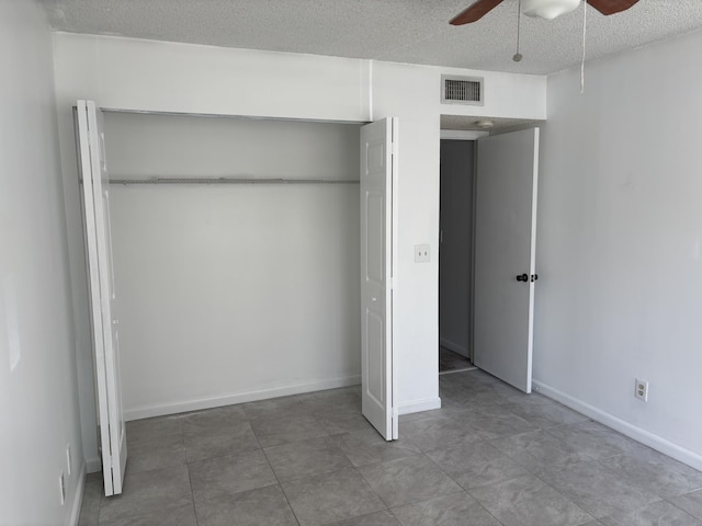 unfurnished bedroom featuring visible vents, a closet, baseboards, a textured ceiling, and ceiling fan
