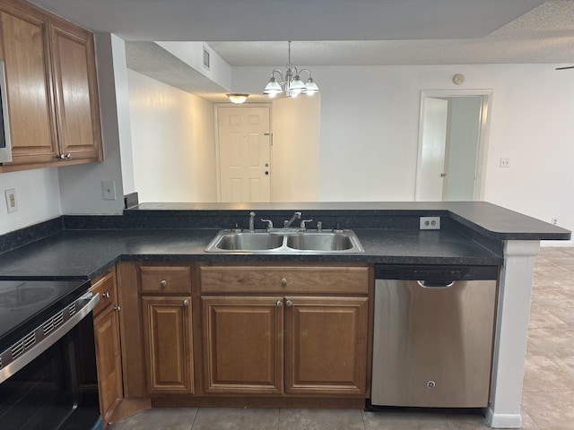 kitchen featuring dark countertops, a sink, light tile patterned floors, dishwasher, and a peninsula