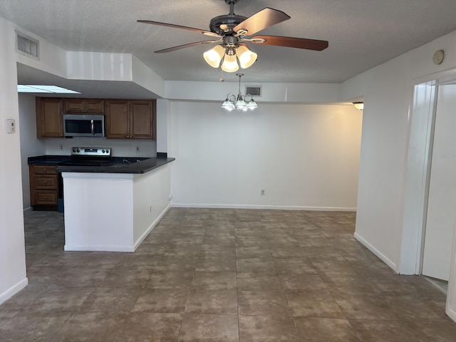 kitchen with dark countertops, a textured ceiling, appliances with stainless steel finishes, and a ceiling fan