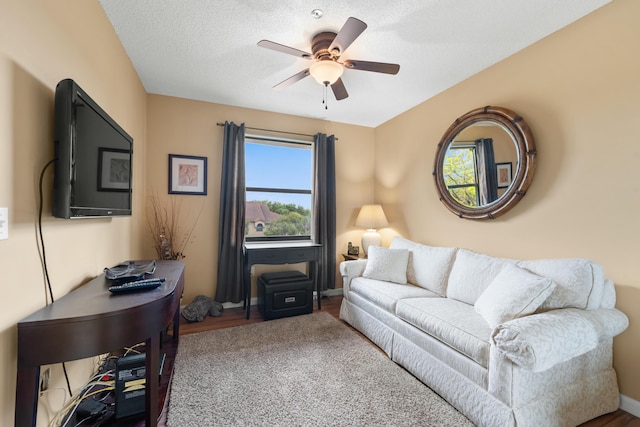 living room with baseboards and a ceiling fan